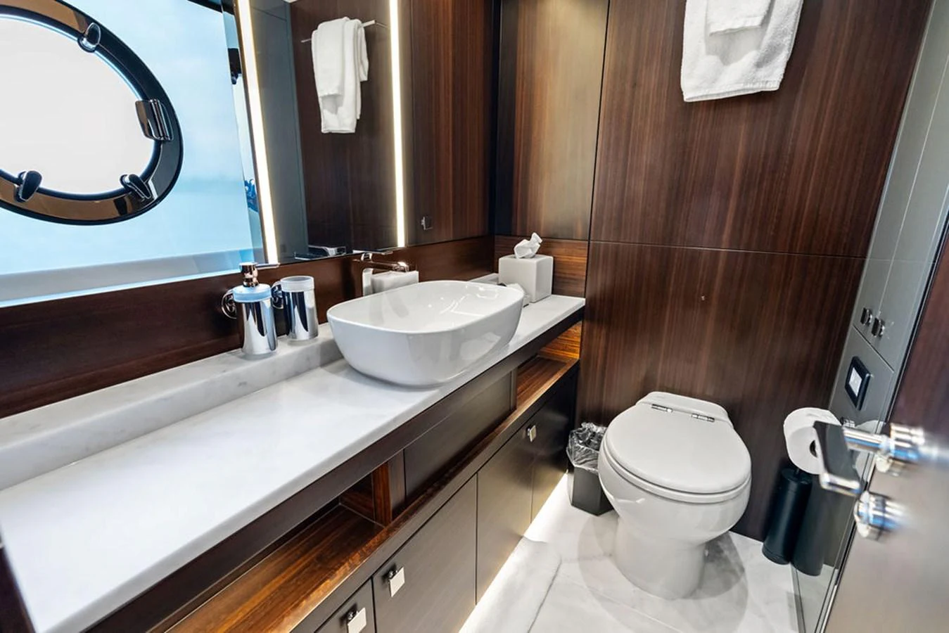 A luxurious yacht bathroom featuring elegant wood paneling and modern fixtures. aboard DOLCE FAR NIENTE Yacht for Sale