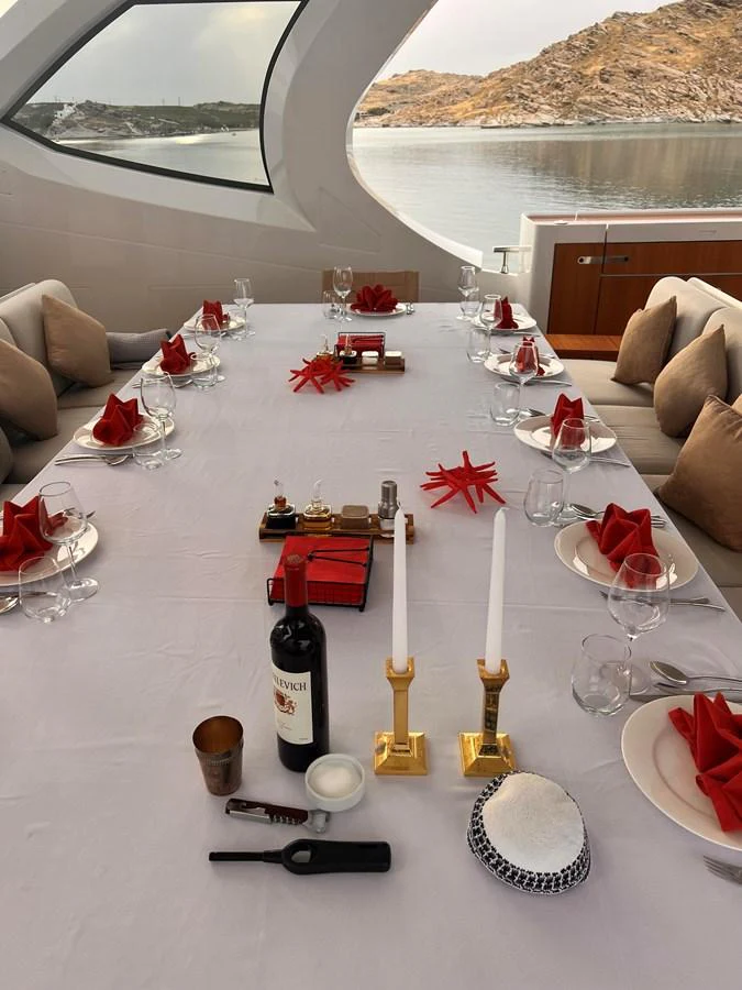 A beautifully set dining table with a scenic view through the yacht's window. aboard DAGUSHA V Yacht for Sale