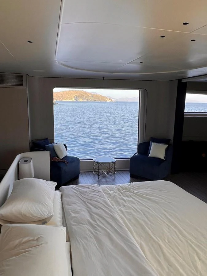 A serene stateroom with a large window offering a stunning ocean view. aboard DAGUSHA V Yacht for Sale