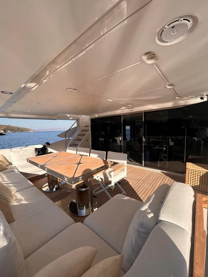 The aft deck offers a comfortable seating area with a dining table, perfect for enjoying meals with a view of the water. aboard DAGUSHA V Yacht for Sale