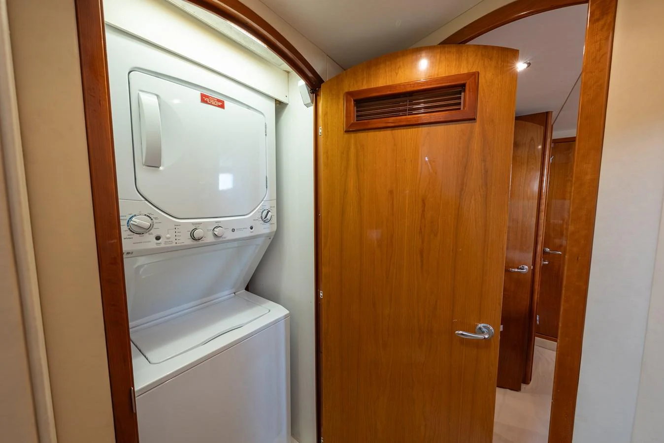 The yacht features a convenient laundry area with a stacked washer and dryer. aboard HAVILAH Yacht for Sale