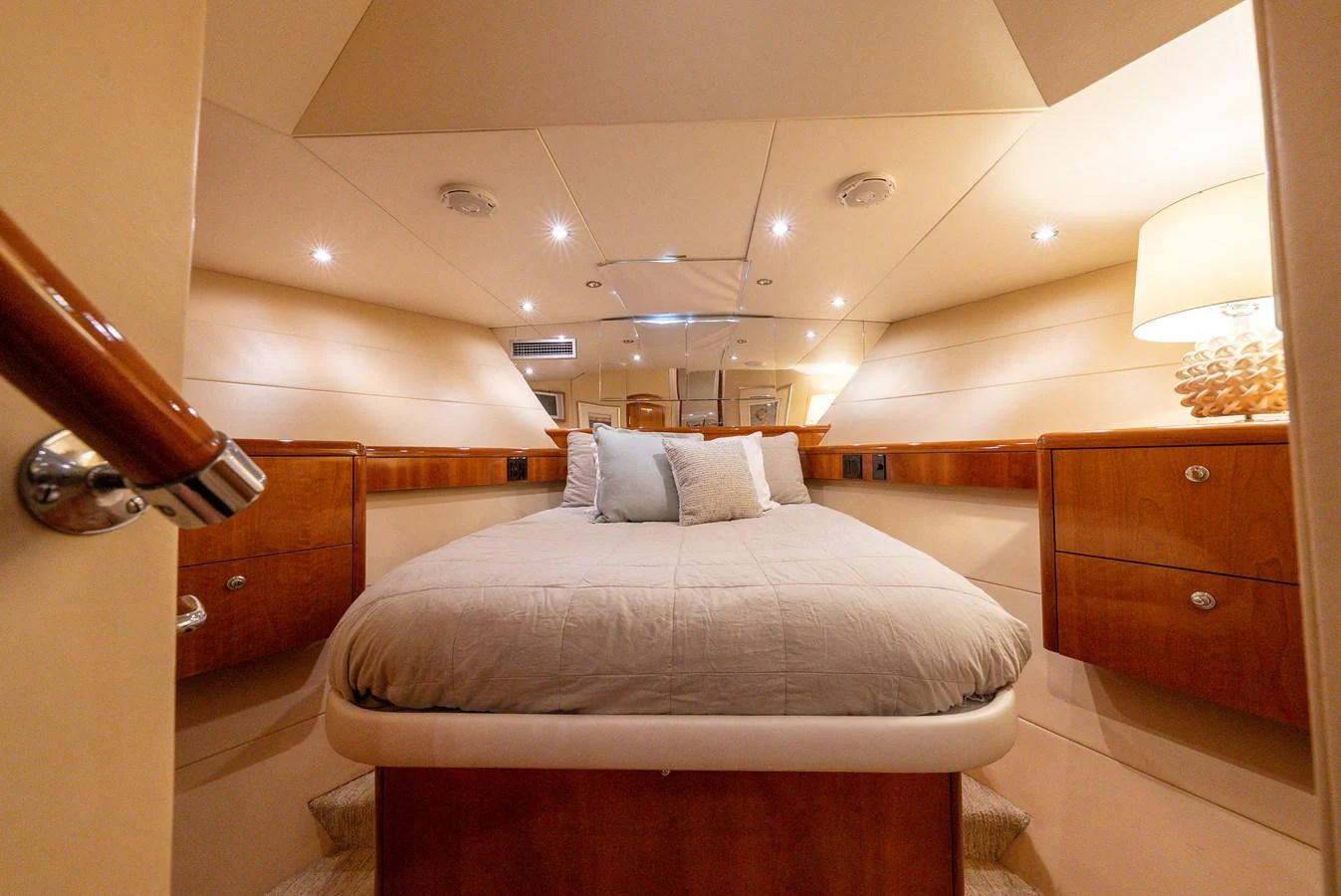 The stateroom features a cozy bed with elegant wooden cabinetry and soft lighting. aboard HAVILAH Yacht for Sale