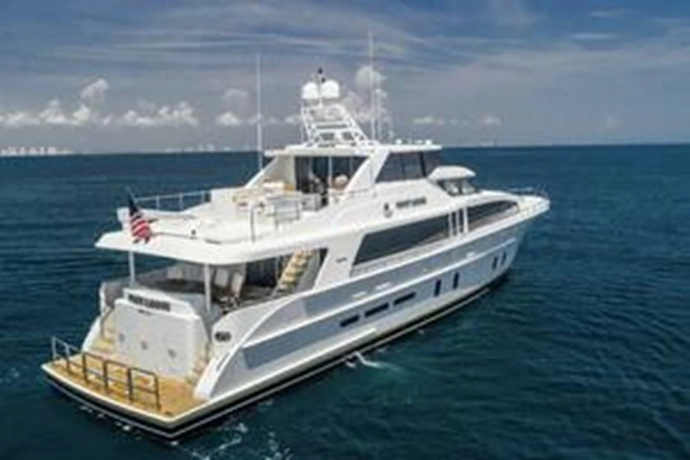 A luxurious yacht cruising on the open sea under a clear blue sky. aboard FOOTLOOSE Yacht for Sale