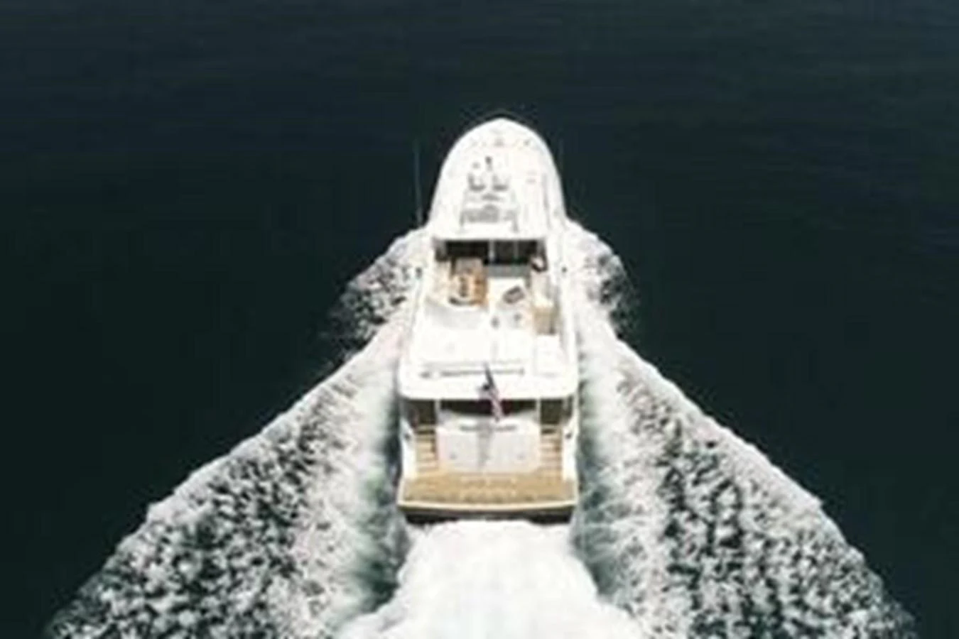 Aerial view of a yacht cruising through calm waters, leaving a wake behind. aboard FOOTLOOSE Yacht for Sale