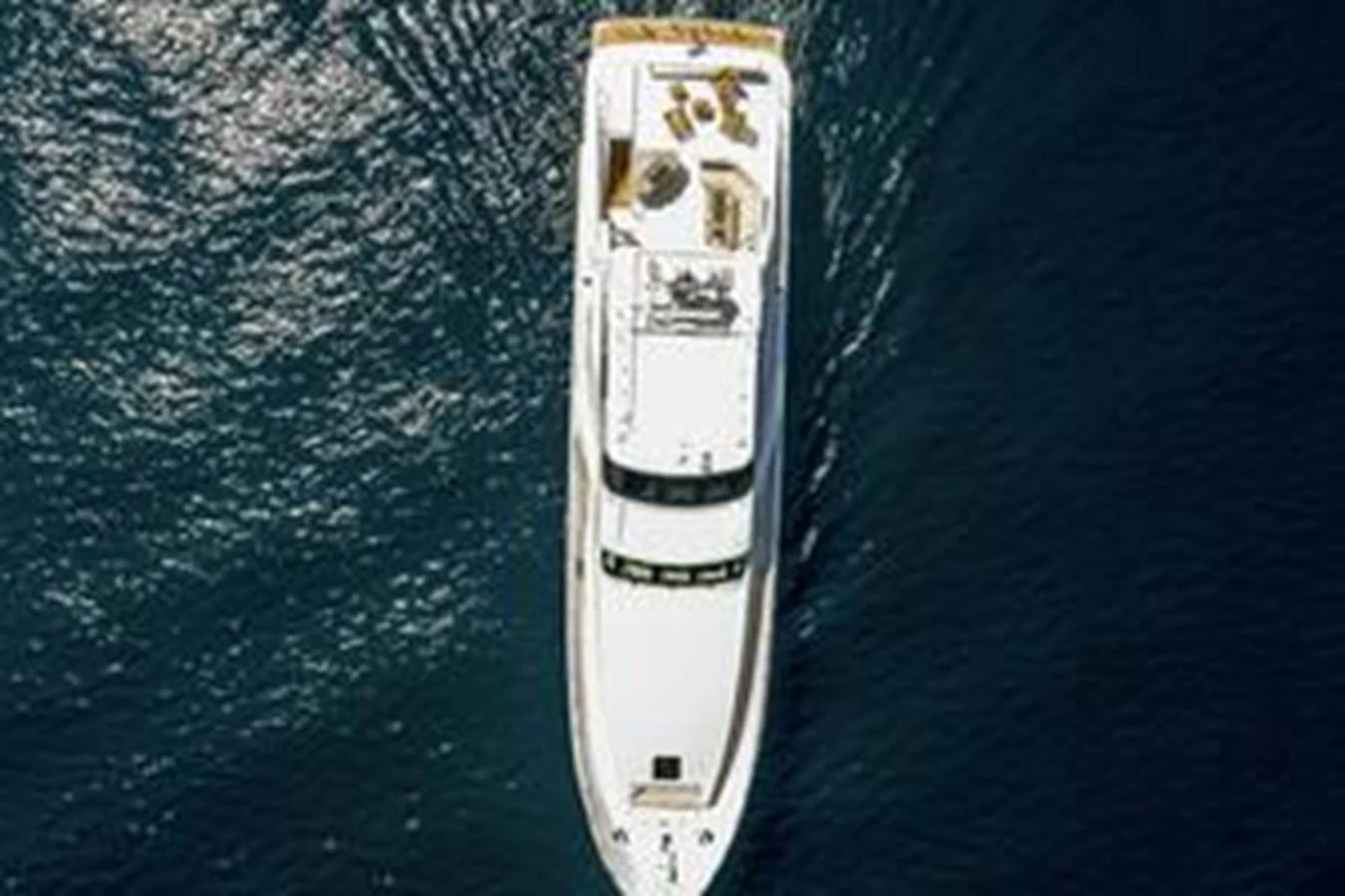 Aerial view of a luxurious yacht cruising on calm waters. aboard FOOTLOOSE Yacht for Sale