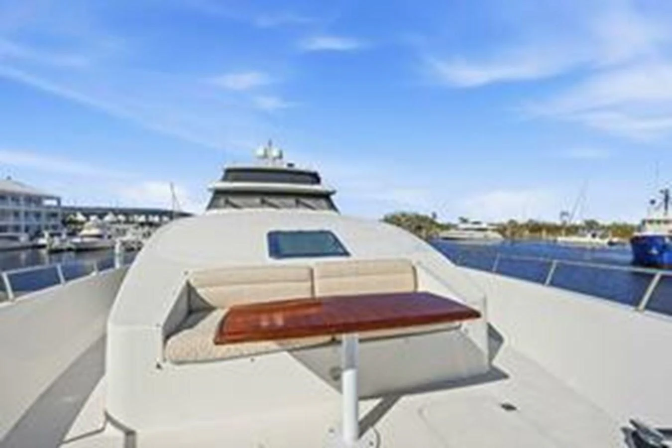 The foredeck features a cozy seating area with a wooden table, perfect for enjoying the view. aboard FOOTLOOSE Yacht for Sale