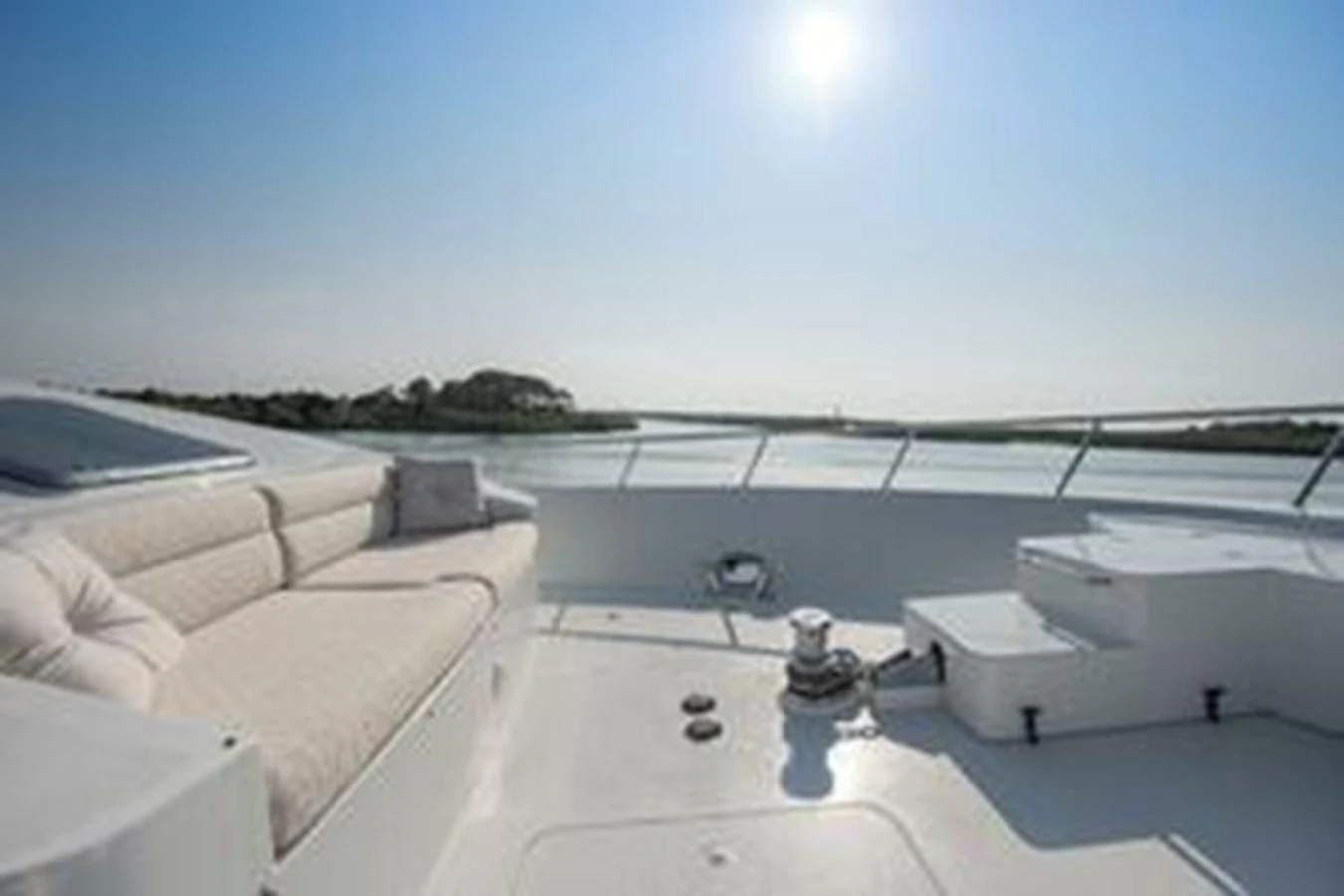 The foredeck offers a serene lounging area with plush seating under the bright sun. aboard FOOTLOOSE Yacht for Sale