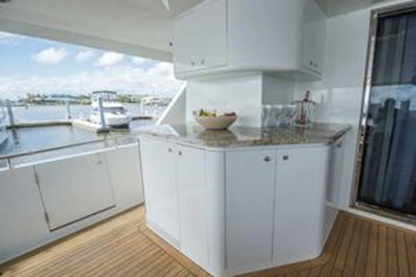 The aft deck features a sleek bar area with a view of the marina. aboard FOOTLOOSE Yacht for Sale