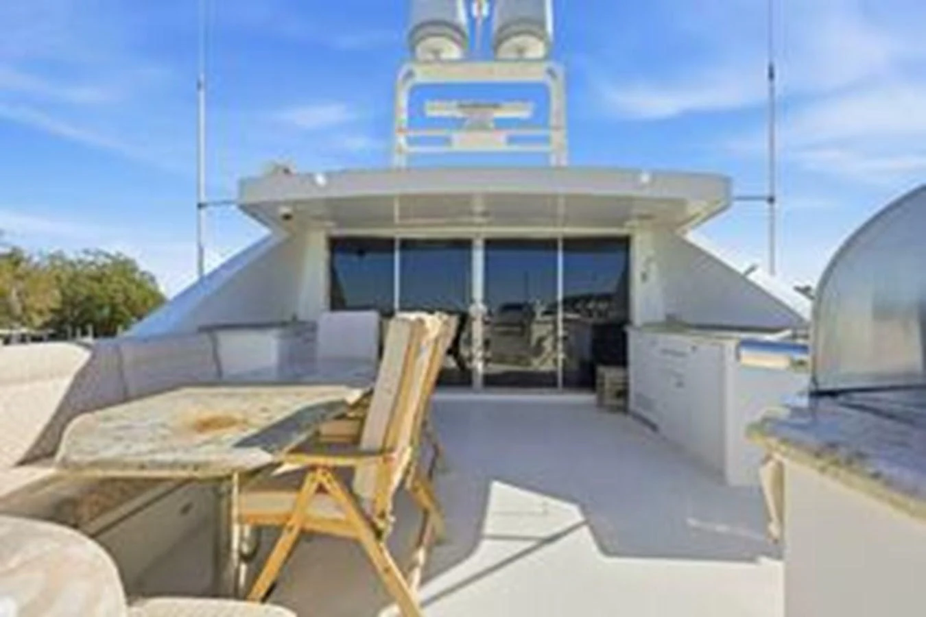 The flybridge offers a spacious outdoor area with comfortable seating and a dining table, perfect for alfresco dining and relaxation. aboard FOOTLOOSE Yacht for Sale