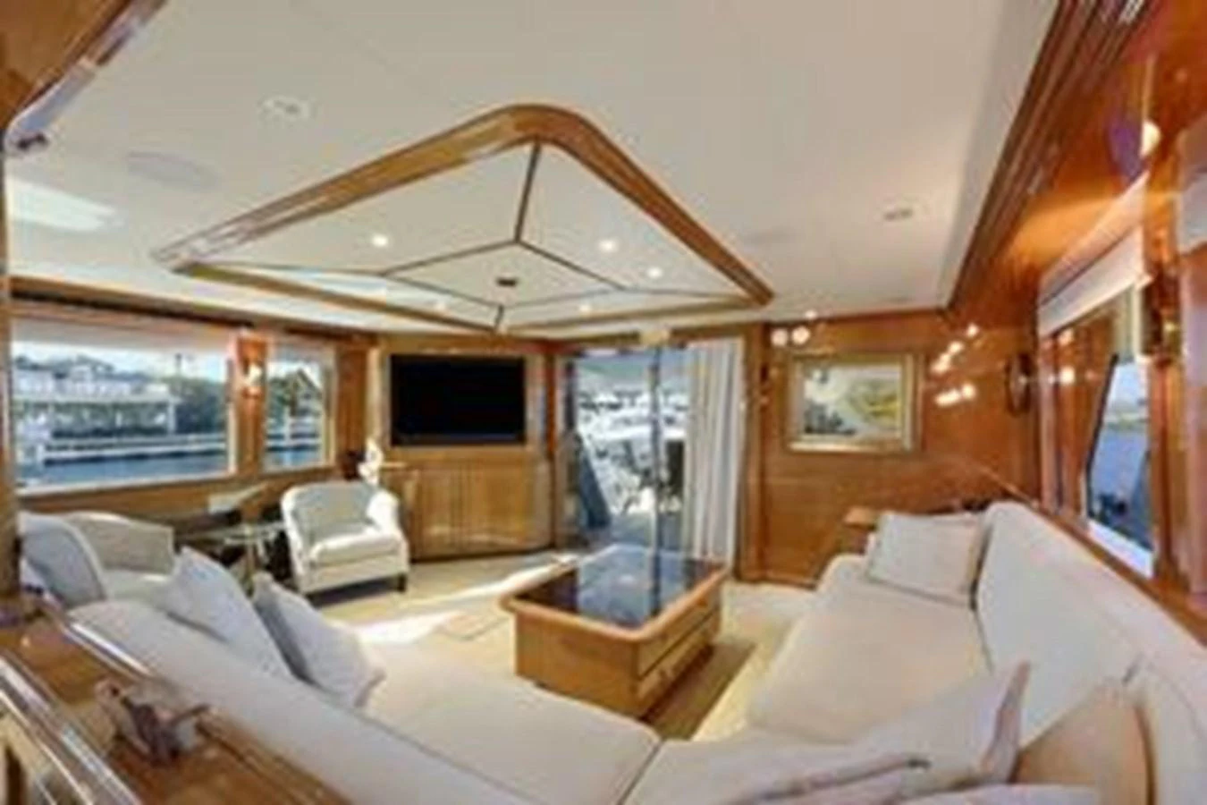 The salon features plush seating, elegant wood finishes, and large windows offering stunning views. aboard FOOTLOOSE Yacht for Sale