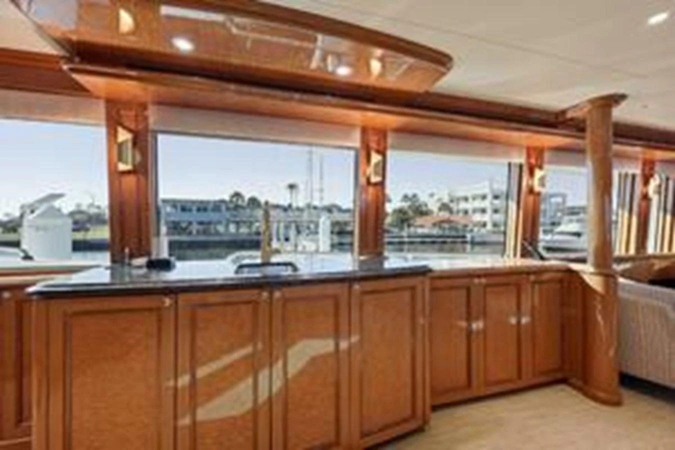 The yacht's salon features elegant wood cabinetry and large windows offering a scenic view. aboard FOOTLOOSE Yacht for Sale