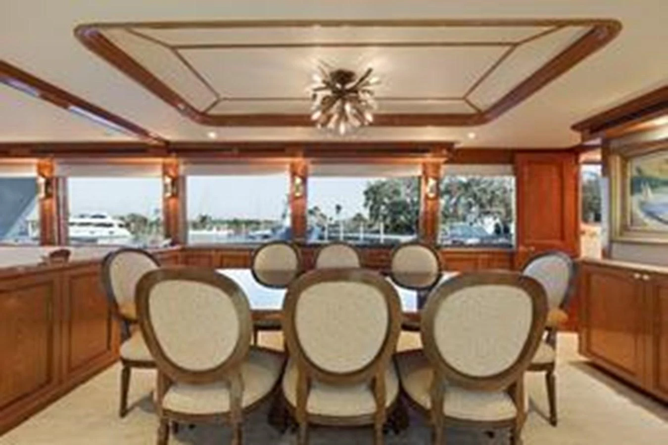 The yacht's dining area features elegant wooden finishes and a large table with comfortable seating for eight. aboard FOOTLOOSE Yacht for Sale