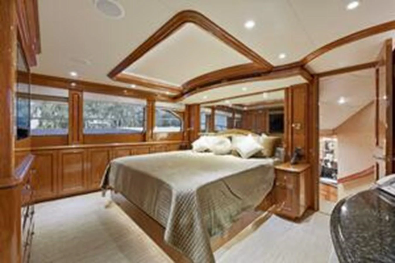 The master stateroom features a luxurious bed with elegant wood finishes and ample natural light. aboard FOOTLOOSE Yacht for Sale