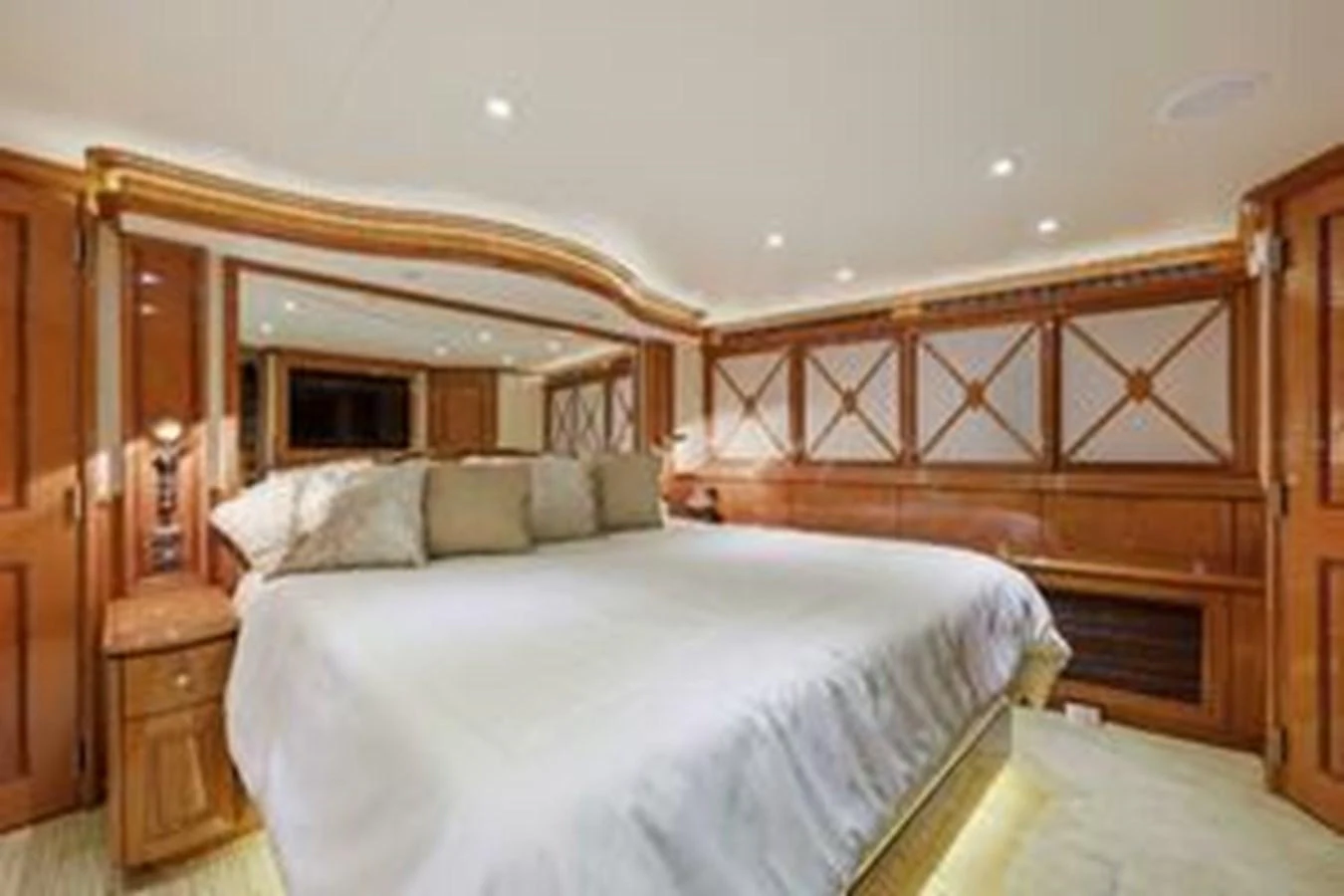 The master stateroom features a spacious bed with elegant wood paneling and ambient lighting. aboard FOOTLOOSE Yacht for Sale