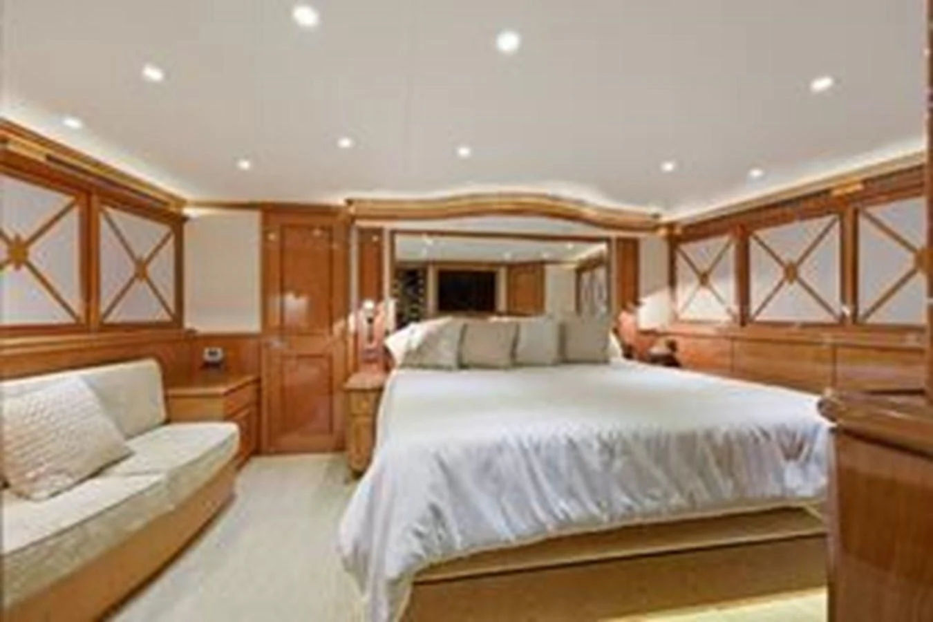 The master stateroom features a spacious bed, elegant wood paneling, and ambient lighting. aboard FOOTLOOSE Yacht for Sale