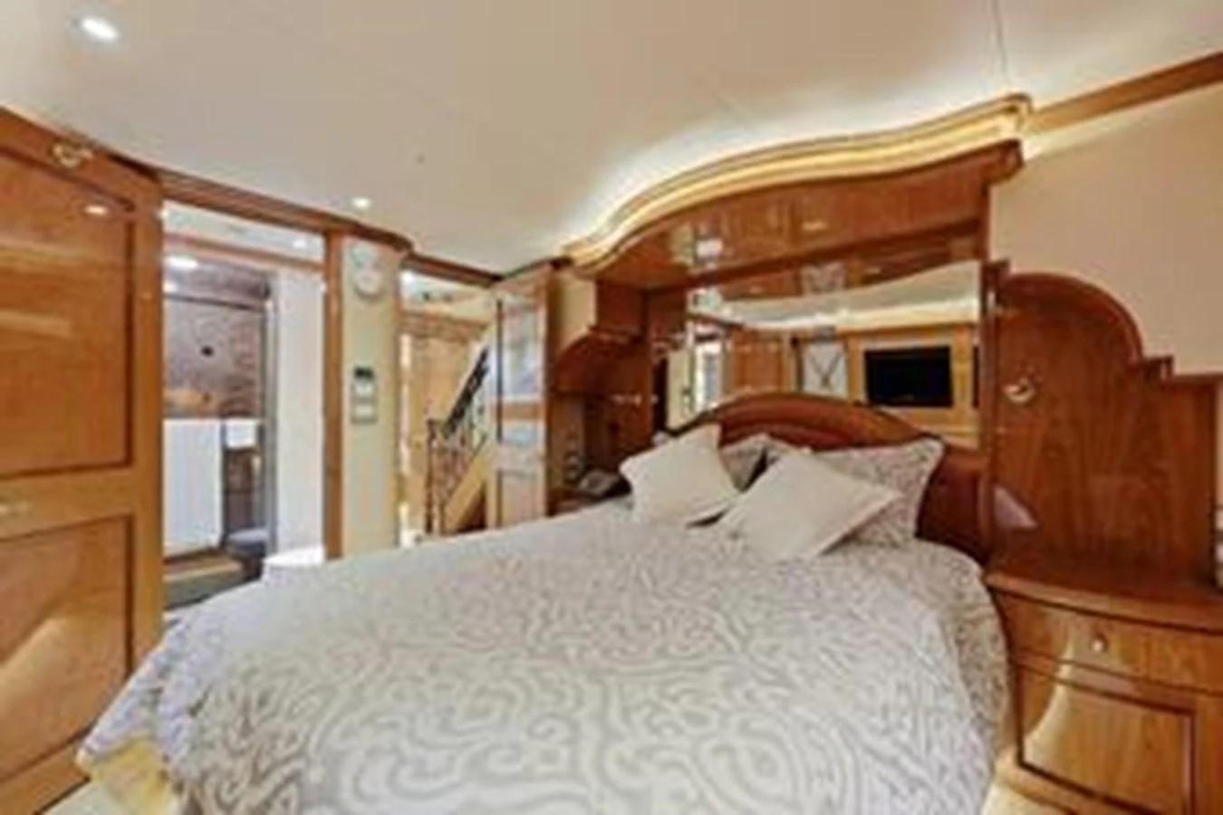 A luxurious stateroom featuring a plush bed and elegant wood finishes. aboard FOOTLOOSE Yacht for Sale