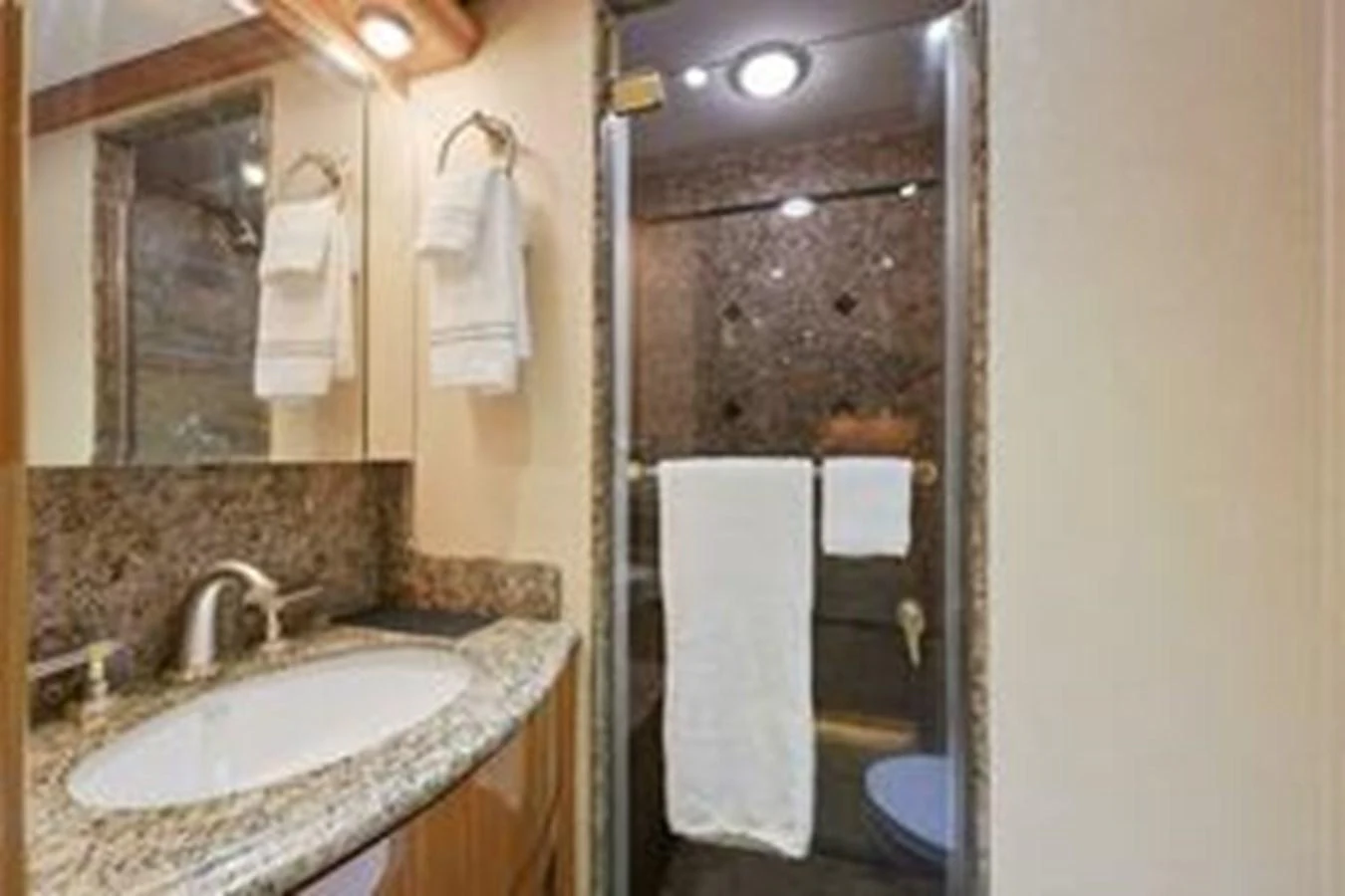 The yacht's bathroom features a granite countertop and a glass-enclosed shower. aboard FOOTLOOSE Yacht for Sale