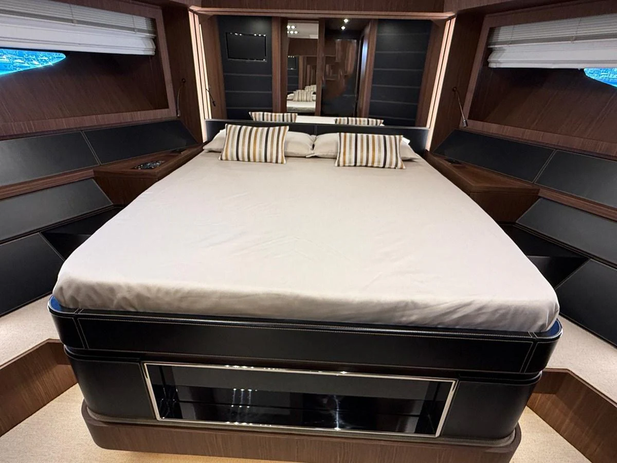 The master stateroom features a spacious bed with elegant wood finishes and ample natural light. aboard ANTIOXIDANT Yacht for Sale