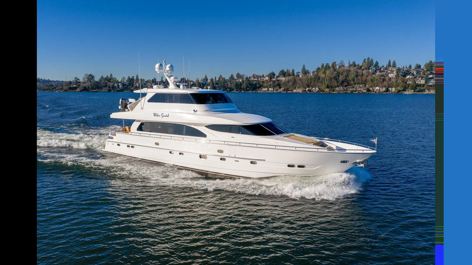 A sleek white yacht cruises gracefully on calm waters under a clear blue sky. aboard WISHES GRANTED Yacht for Sale