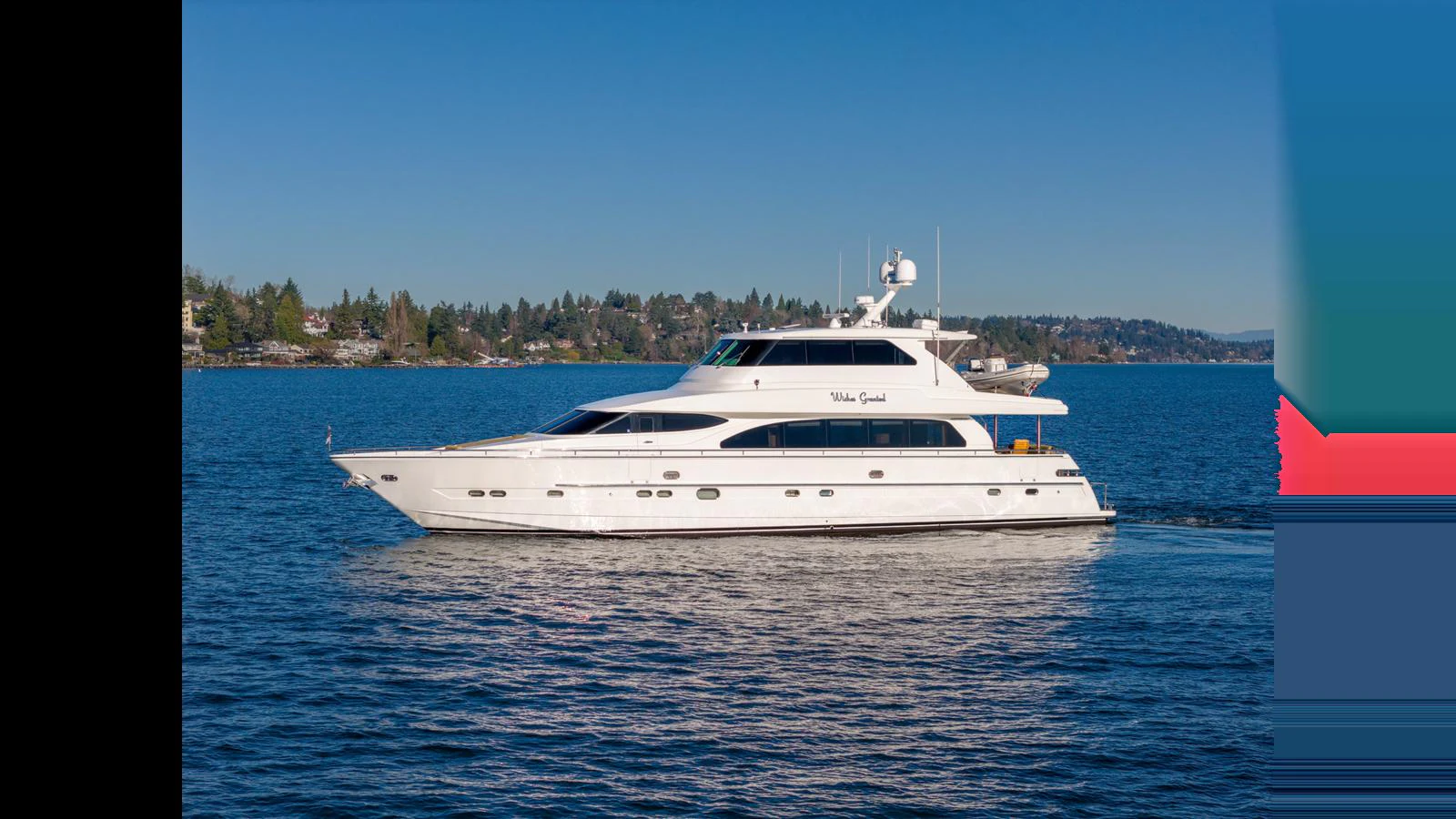 A sleek white yacht cruises gracefully on calm blue waters with a scenic shoreline in the background. aboard WISHES GRANTED Yacht for Sale