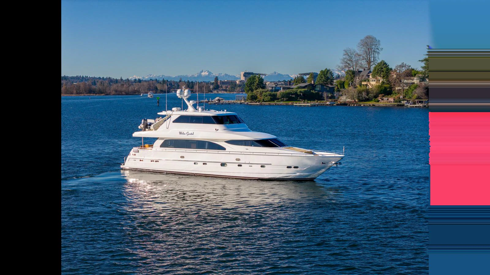 A sleek white yacht glides gracefully on calm blue waters with a scenic shoreline in the background. aboard WISHES GRANTED Yacht for Sale