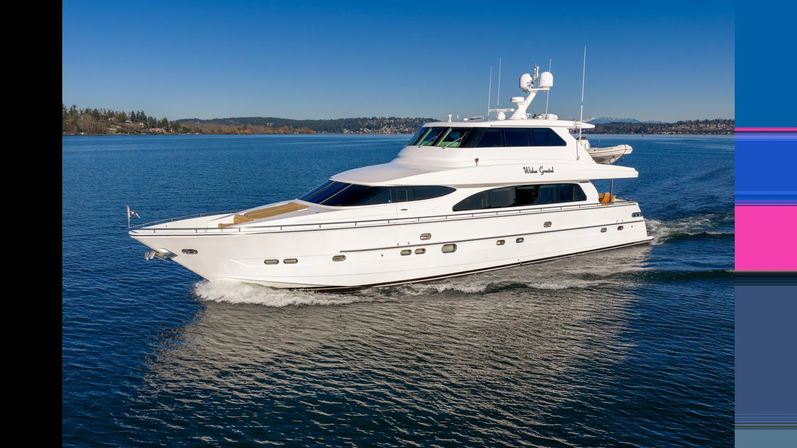 A sleek white yacht cruises smoothly on calm blue waters under a clear sky. aboard WISHES GRANTED Yacht for Sale