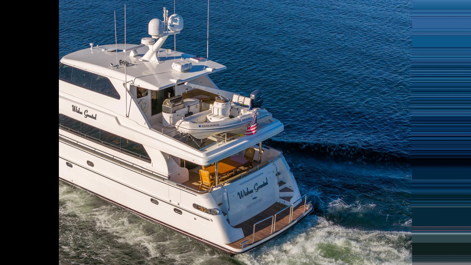 A luxurious yacht cruises through the water, showcasing its elegant design and spacious decks. aboard WISHES GRANTED Yacht for Sale