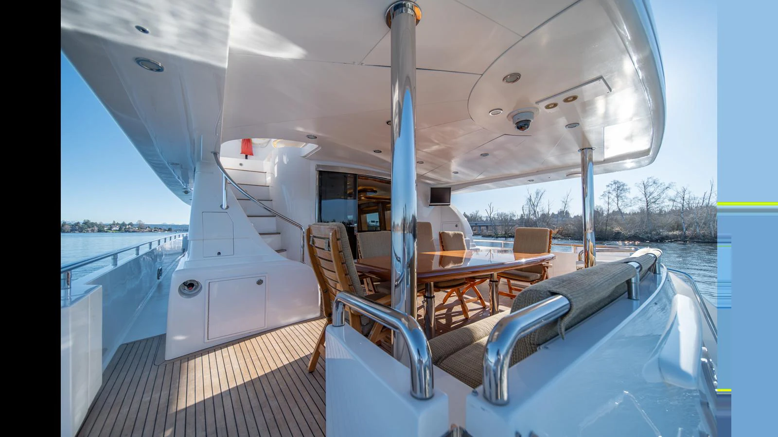 The aft deck features a spacious seating area with a dining table, perfect for outdoor relaxation and dining. aboard WISHES GRANTED Yacht for Sale