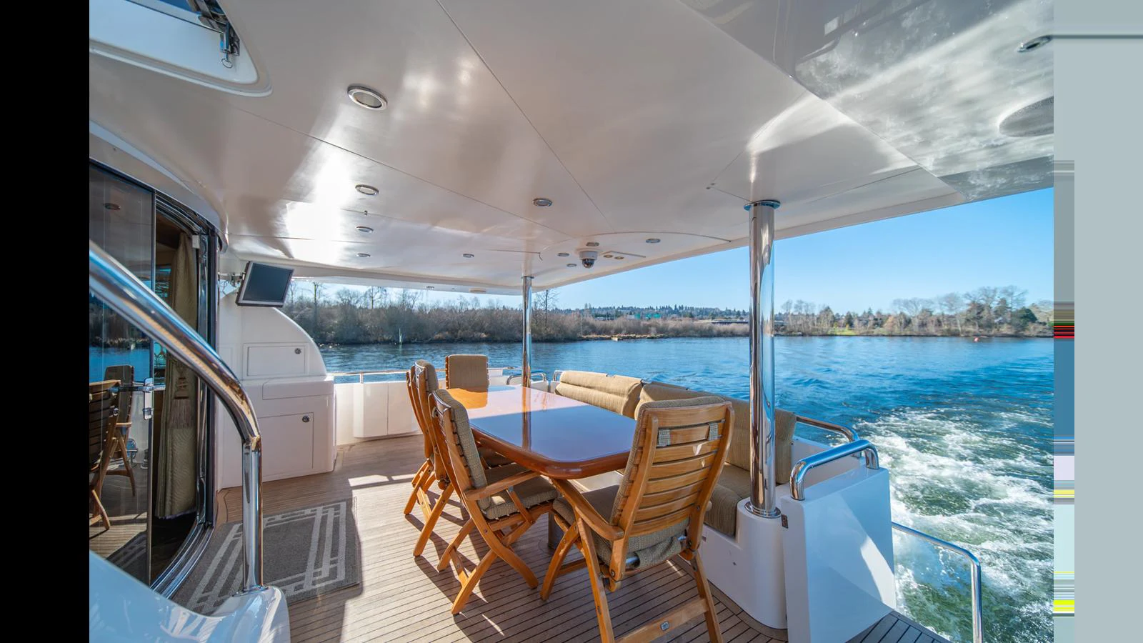 The aft deck features a spacious dining area with a beautiful view of the water. aboard WISHES GRANTED Yacht for Sale
