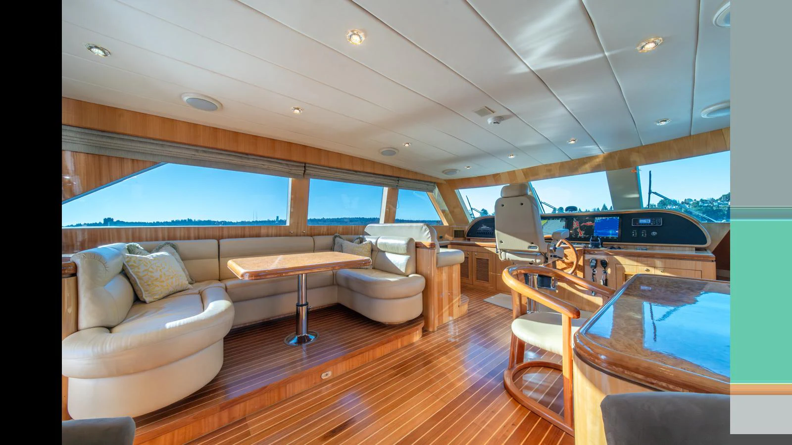 The yacht's salon features luxurious seating, a dining area, and expansive windows offering stunning views. aboard WISHES GRANTED Yacht for Sale