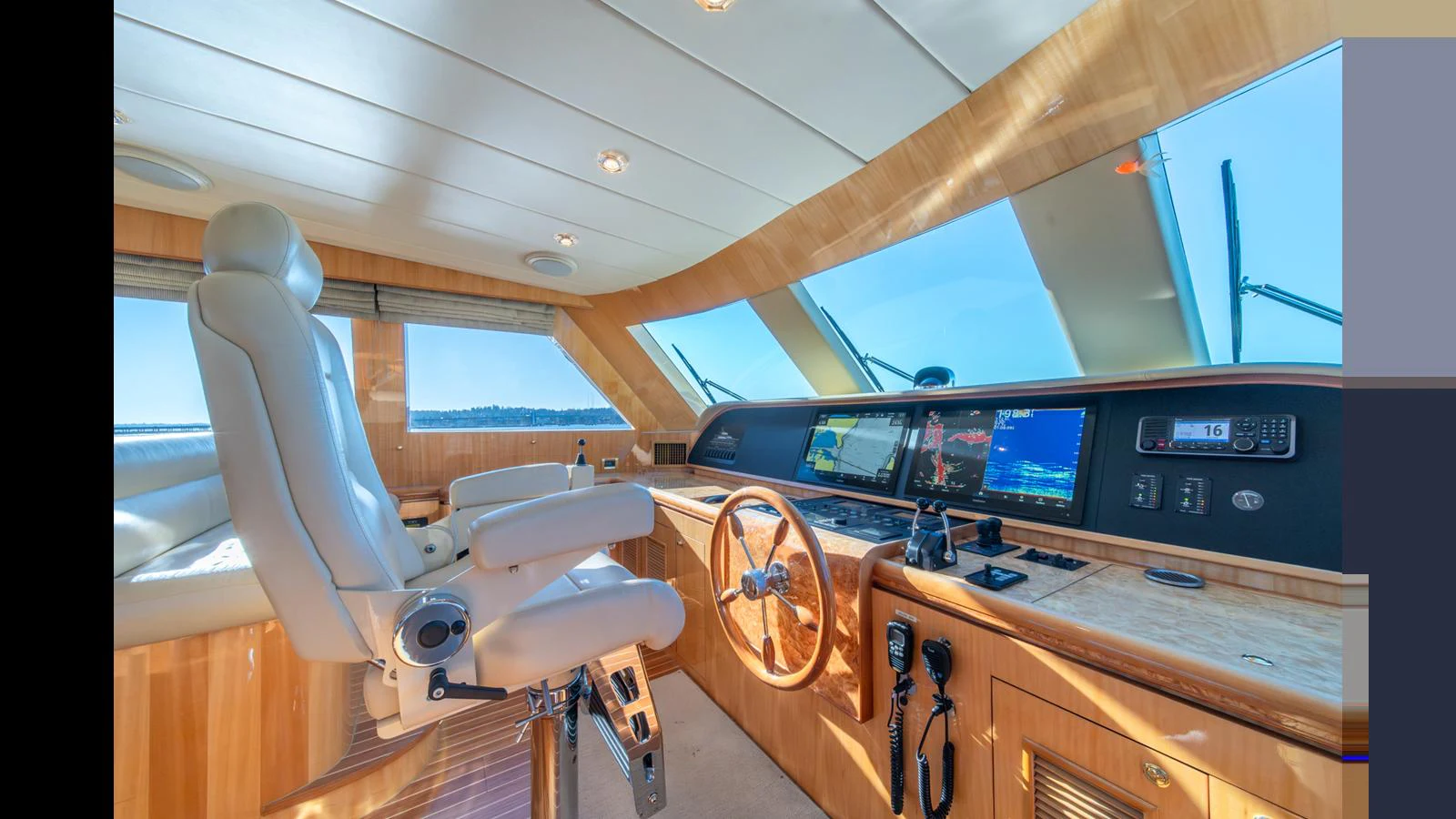 The helm station features a luxurious captain's chair and state-of-the-art navigation equipment, bathed in natural light. aboard WISHES GRANTED Yacht for Sale
