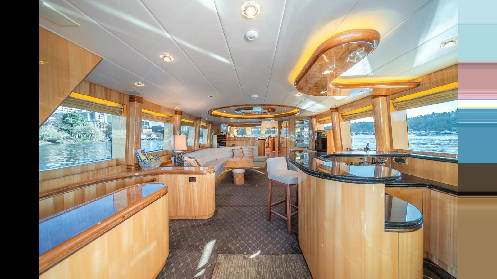 The salon features elegant wood finishes, plush seating, and panoramic windows offering stunning views. aboard WISHES GRANTED Yacht for Sale