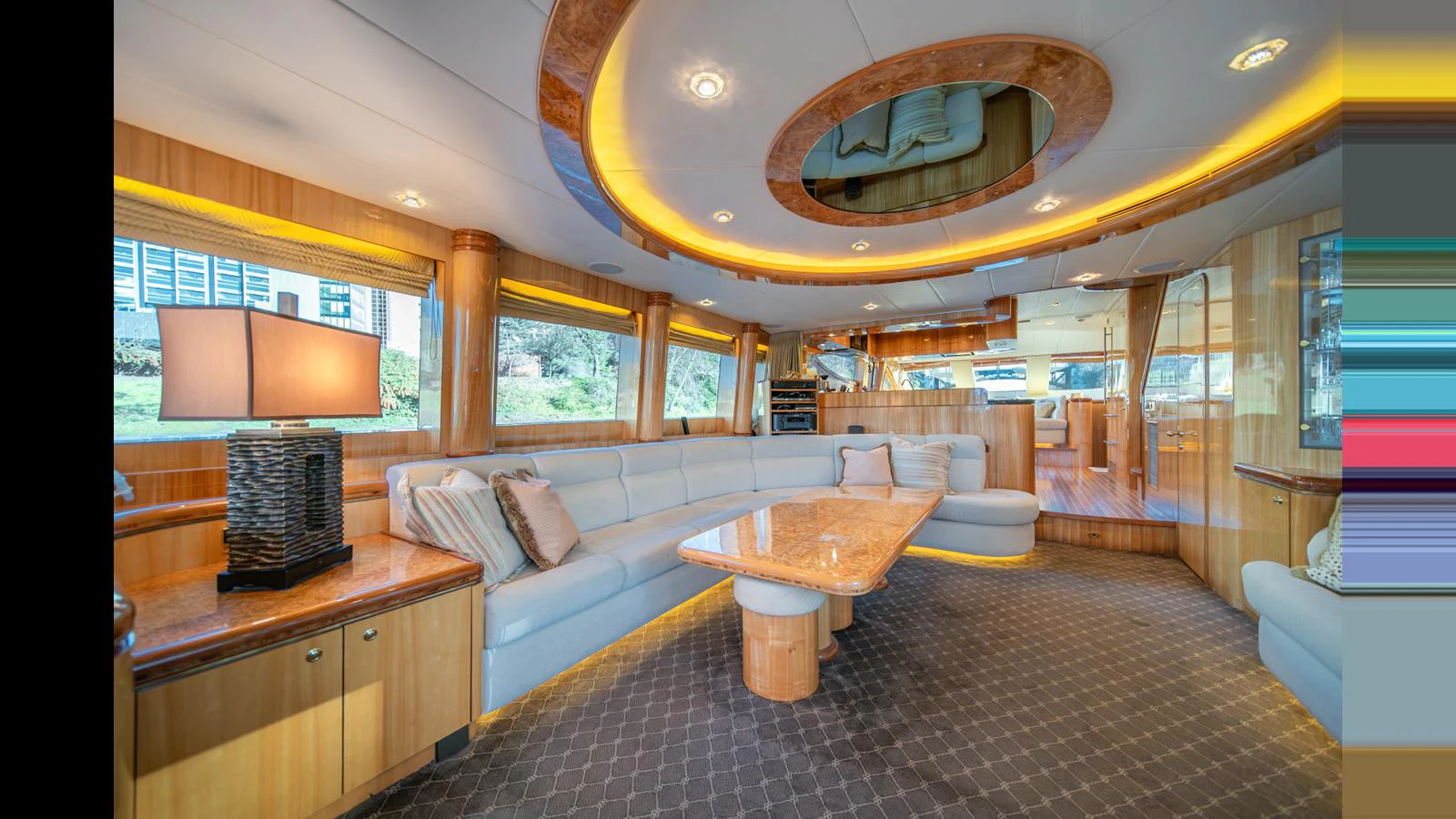 The spacious salon features luxurious seating and elegant wood finishes, creating a warm and inviting atmosphere. aboard WISHES GRANTED Yacht for Sale