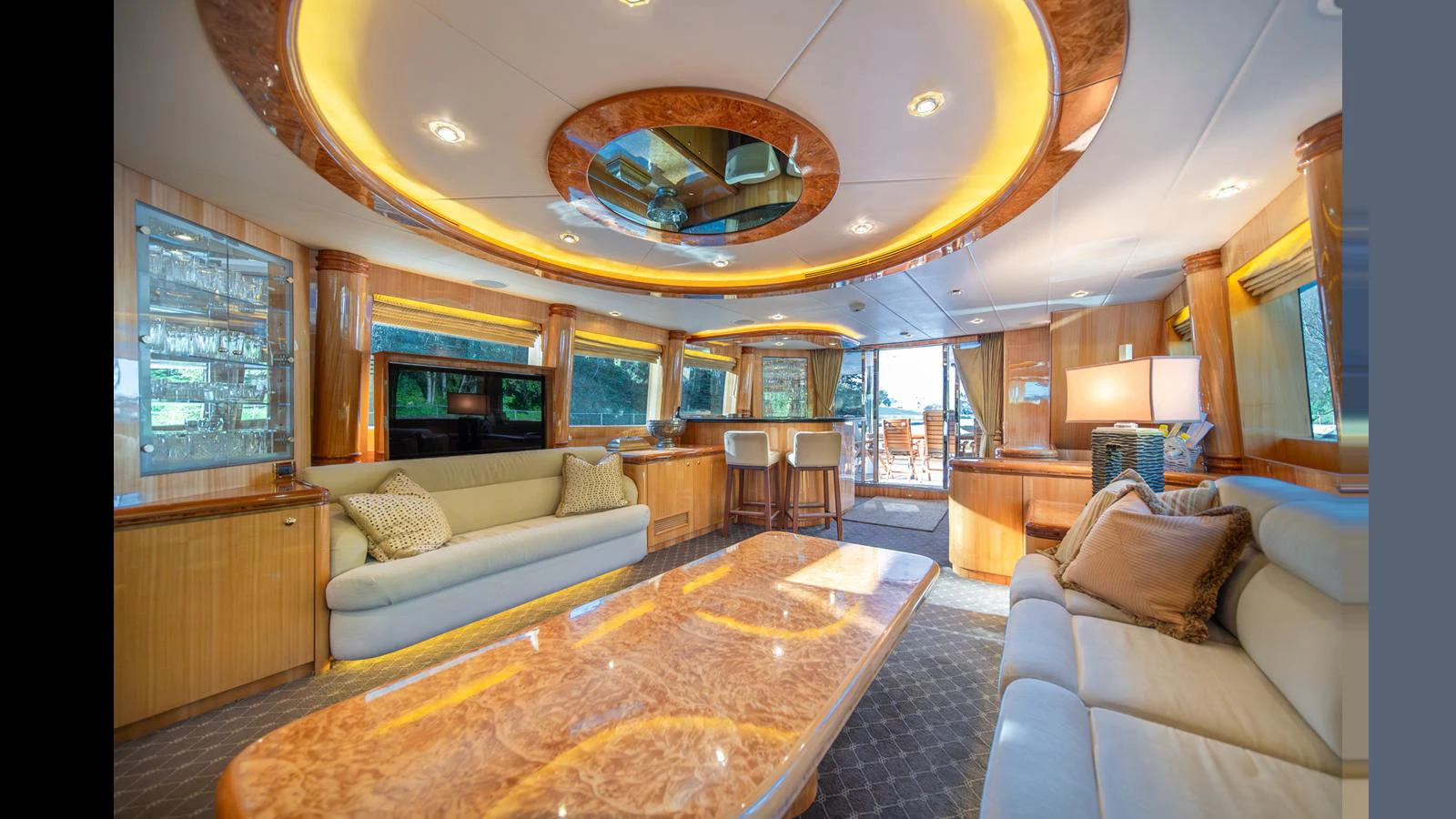 The luxurious salon features elegant wood finishes, plush seating, and ample natural light. aboard WISHES GRANTED Yacht for Sale