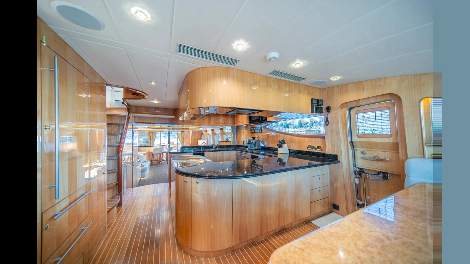 The yacht's galley features sleek wooden cabinetry and modern appliances, creating a warm and inviting space. aboard WISHES GRANTED Yacht for Sale