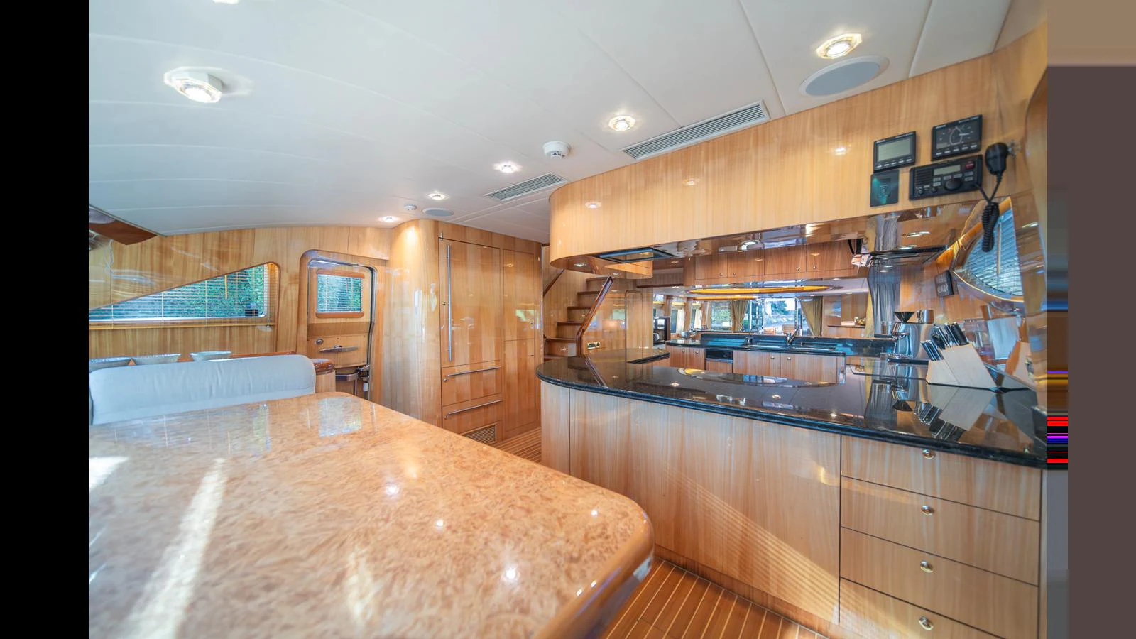 The yacht's galley features luxurious wood finishes and modern appliances, creating a warm and inviting atmosphere. aboard WISHES GRANTED Yacht for Sale