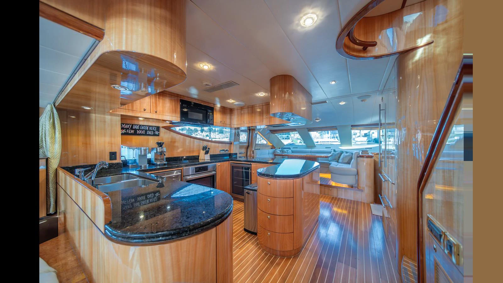 The yacht's galley features sleek wooden cabinetry and modern appliances, creating a warm and inviting space. aboard WISHES GRANTED Yacht for Sale