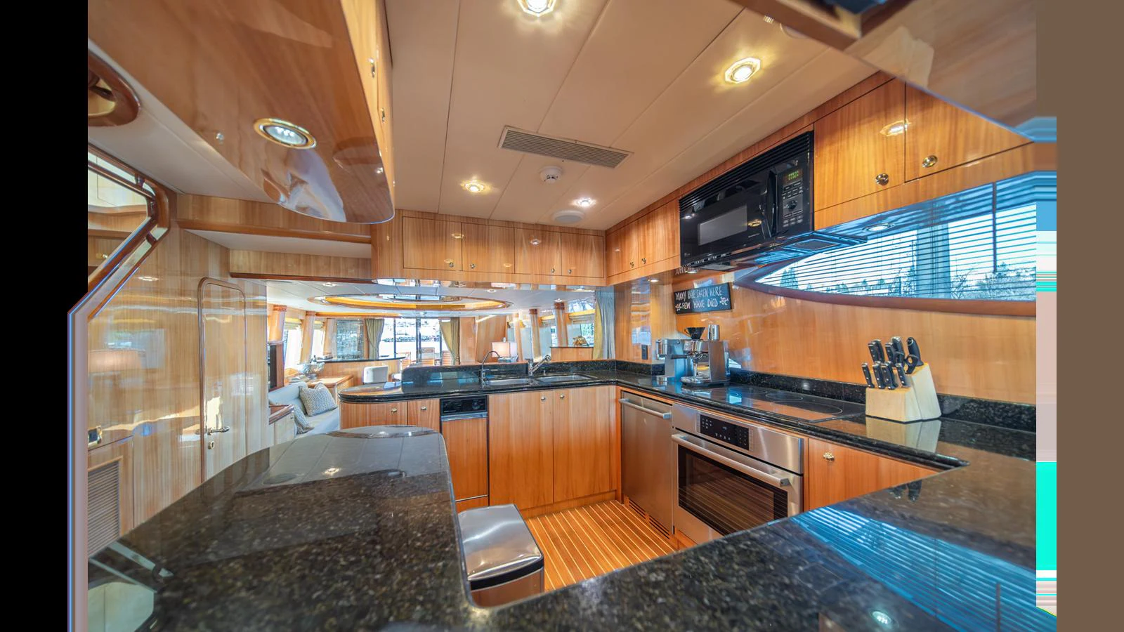The yacht's galley features modern appliances and sleek wooden cabinetry, creating a warm and functional space. aboard WISHES GRANTED Yacht for Sale