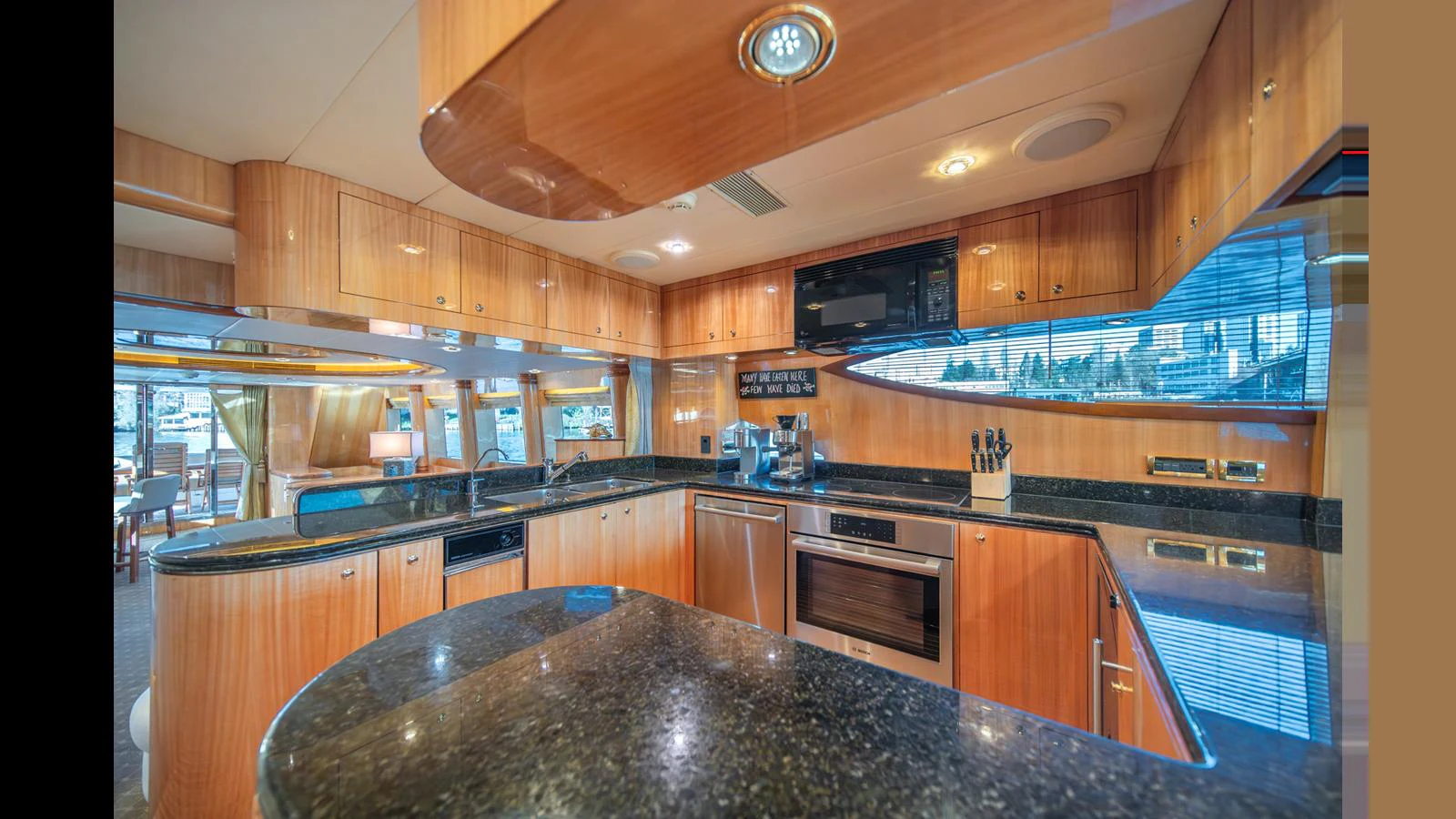 The galley features modern appliances and sleek wooden cabinetry, creating a warm and functional space. aboard WISHES GRANTED Yacht for Sale