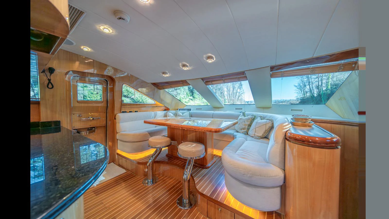The yacht's salon features plush seating, a dining area, and large windows for natural light. aboard WISHES GRANTED Yacht for Sale