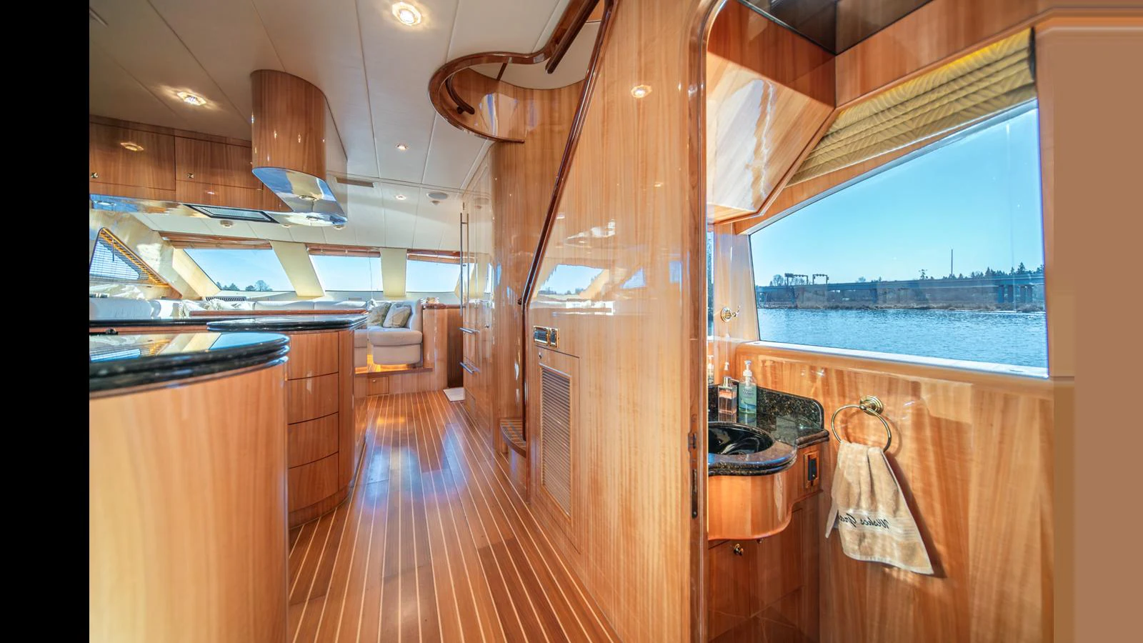 The main salon features luxurious wood finishes and expansive windows offering stunning water views. aboard WISHES GRANTED Yacht for Sale