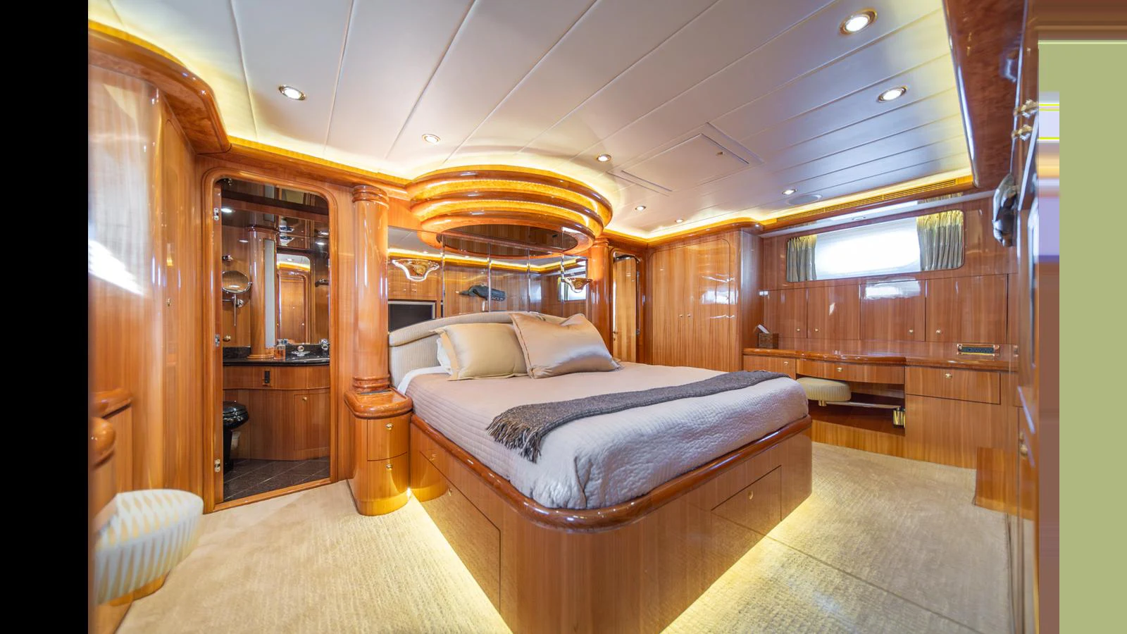 The master stateroom features luxurious wood paneling and ambient lighting, creating a warm and inviting atmosphere. aboard WISHES GRANTED Yacht for Sale