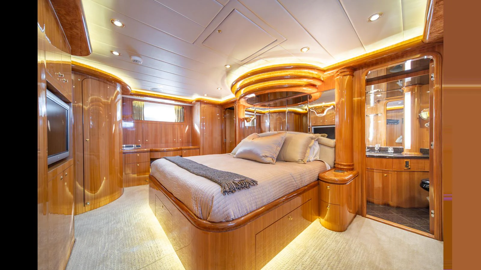 The master stateroom exudes luxury with its warm wood finishes and ambient lighting. aboard WISHES GRANTED Yacht for Sale
