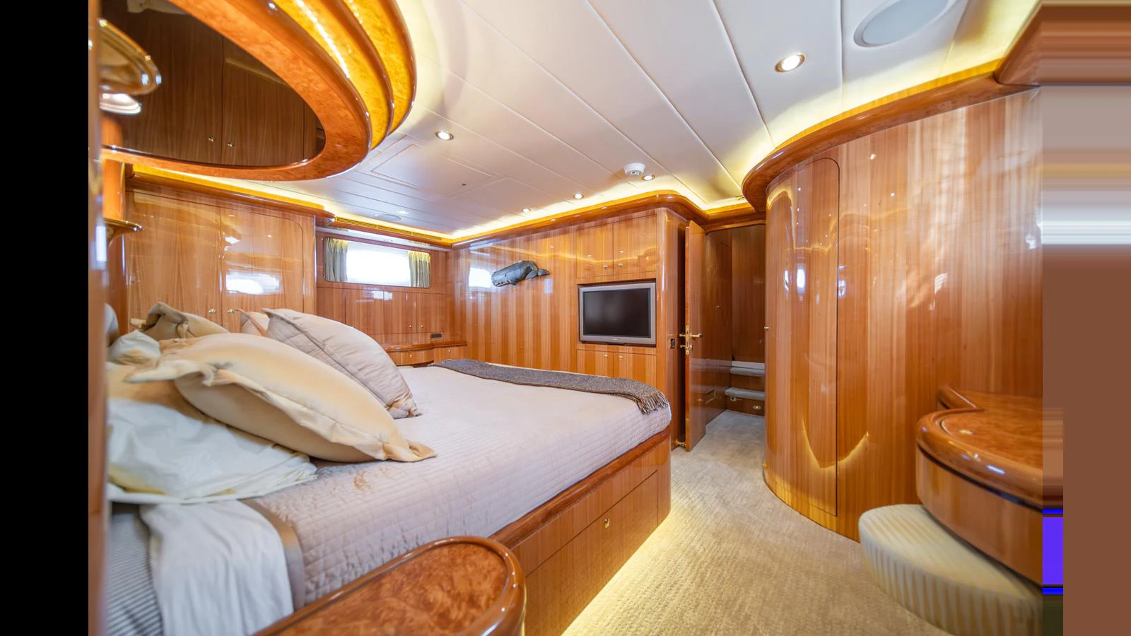 The master stateroom features luxurious wood paneling, a large bed, and modern amenities. aboard WISHES GRANTED Yacht for Sale