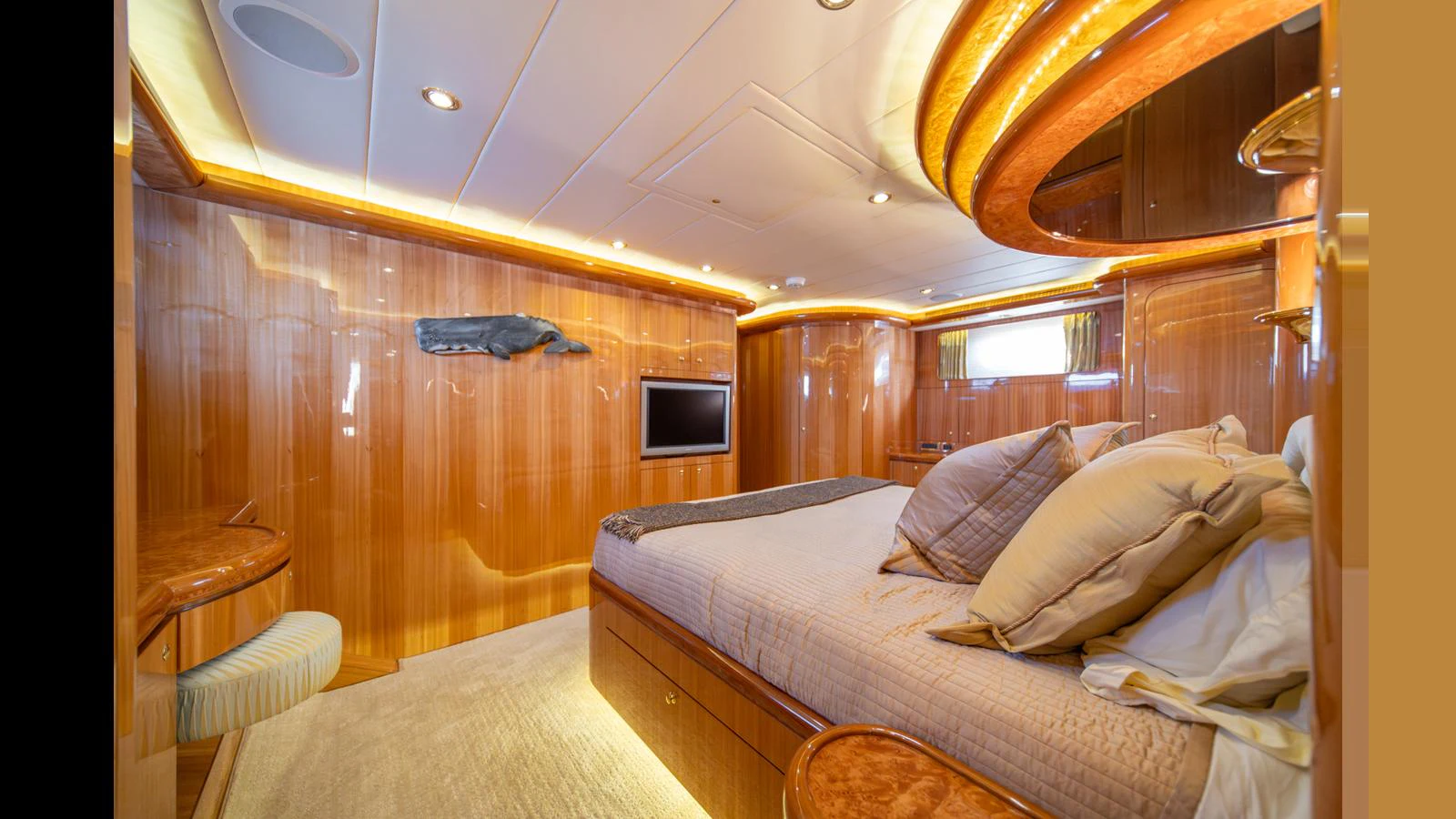 A luxurious stateroom with warm wood paneling and ambient lighting. aboard WISHES GRANTED Yacht for Sale
