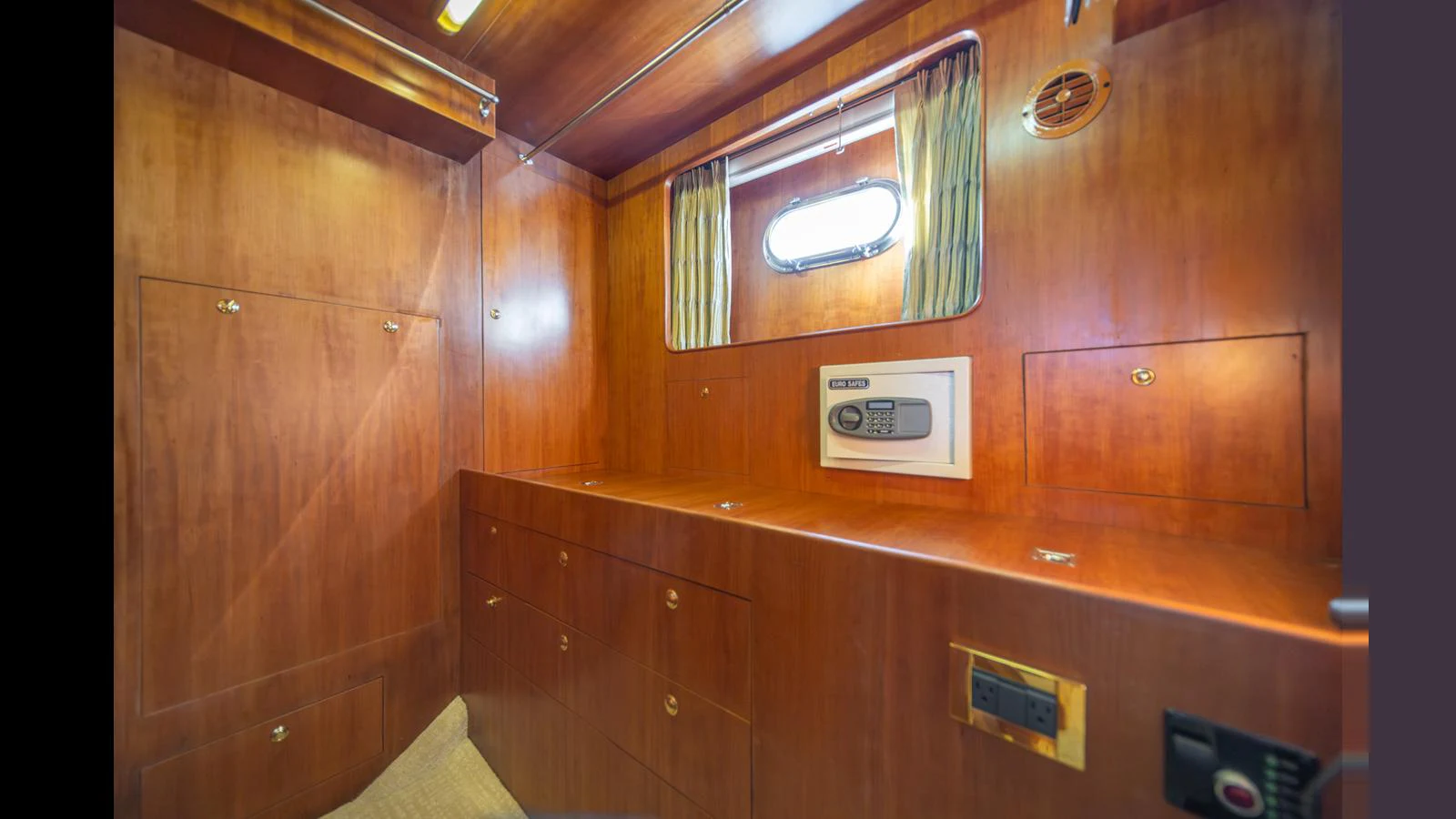The yacht's interior features a secure storage area with a built-in safe and ample cabinetry. aboard WISHES GRANTED Yacht for Sale