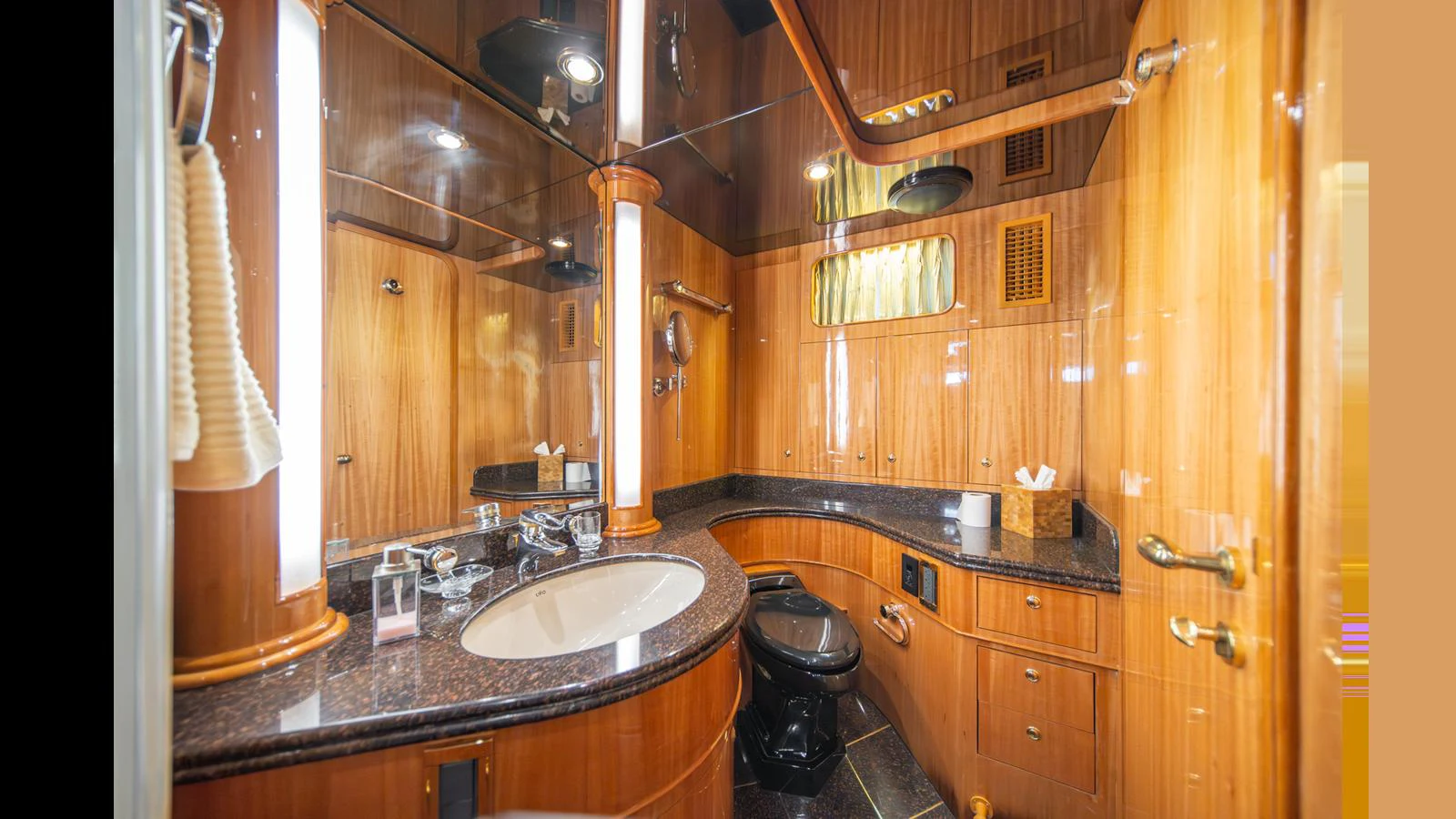 The yacht's bathroom features luxurious wood paneling and modern fixtures. aboard WISHES GRANTED Yacht for Sale