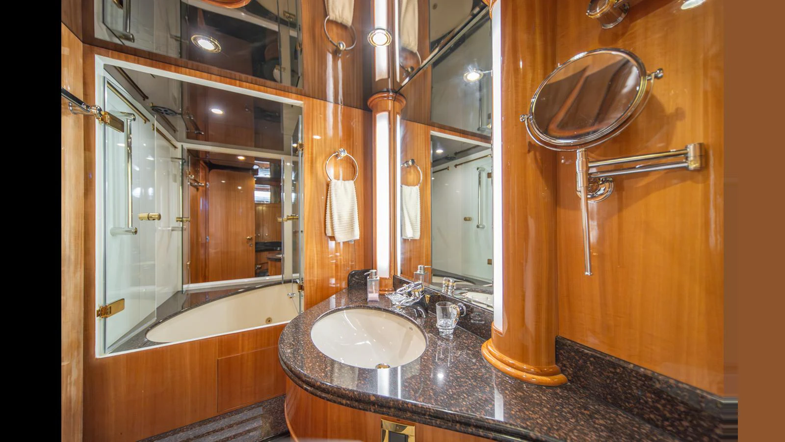 The yacht's bathroom features luxurious wood paneling and a sleek countertop with modern fixtures. aboard WISHES GRANTED Yacht for Sale