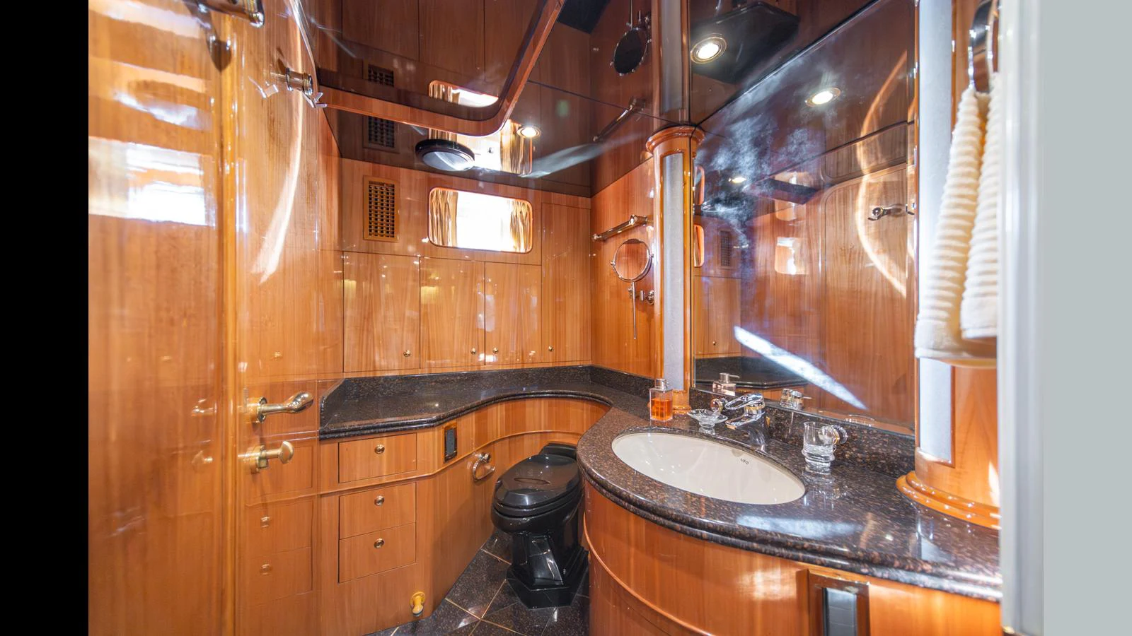The yacht's bathroom features luxurious wood paneling and modern fixtures. aboard WISHES GRANTED Yacht for Sale