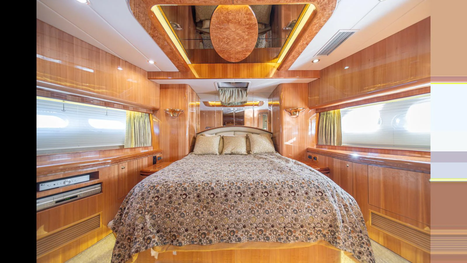 The master stateroom features a luxurious bed with elegant wood paneling and ambient lighting. aboard WISHES GRANTED Yacht for Sale